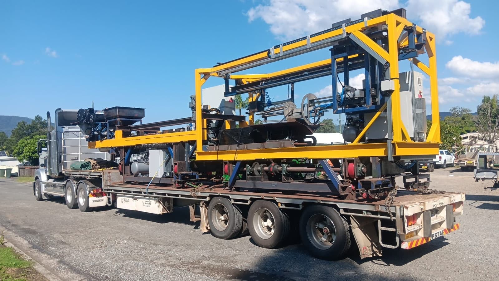 Quick Cargo flat-top truck carrying oversized manufacturing equipment